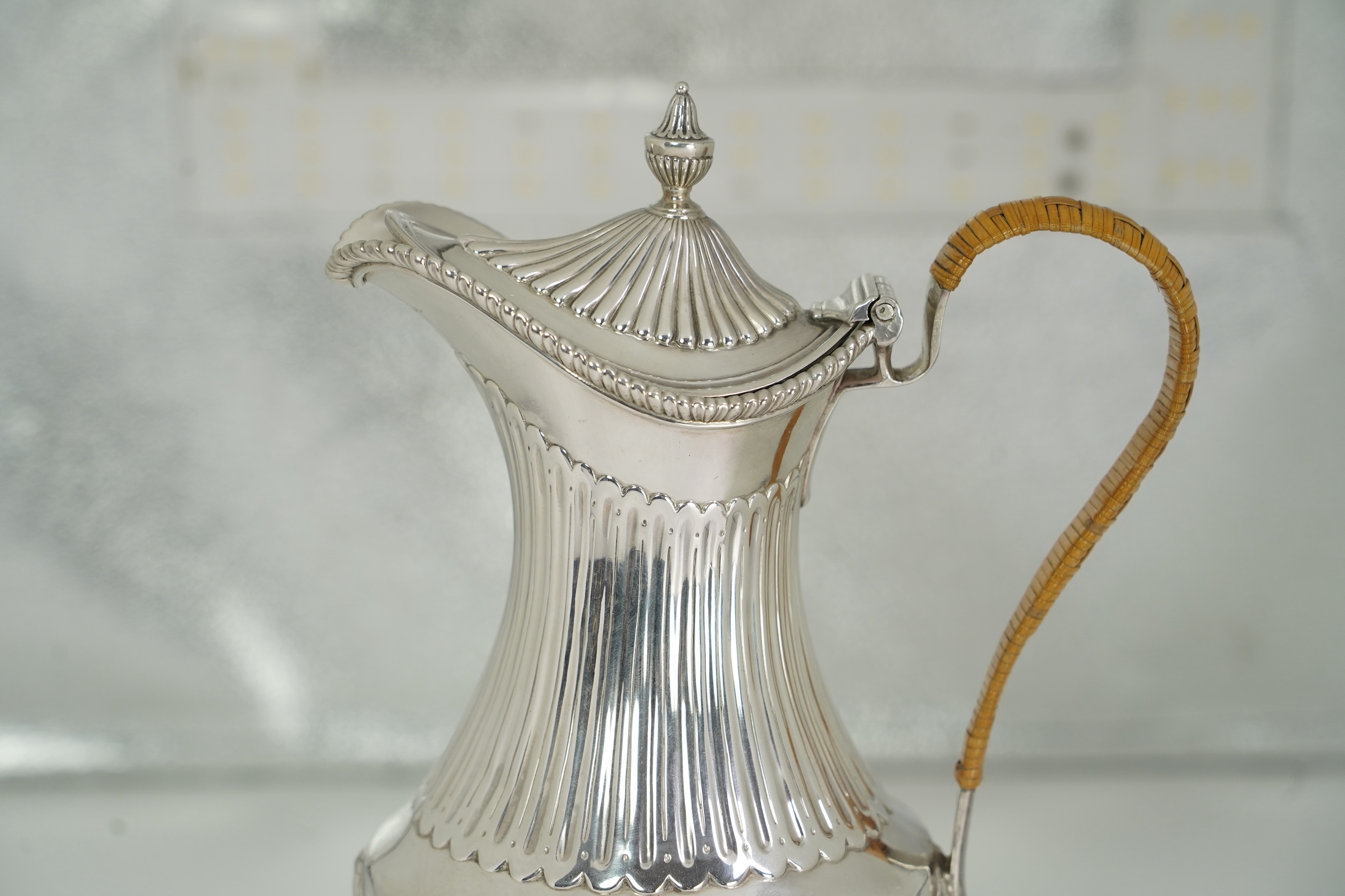 A George III neo-classical silver pedestal hot water pot, by Augustin Le Sage, engraved with the crest of The Right Reverend Robert Lowth, Bishop of London, (1710-1787)
